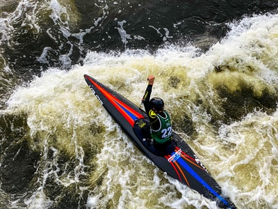 在蓝色和红色西装骑在蓝色和红色kayak
